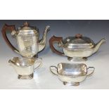 A silver four piece tea set of rectangular form with canted corners, decorated with a scallop shell,