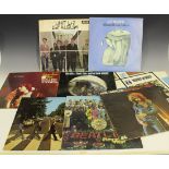A collection of records, including albums by The Beatles and The Rolling Stones.
