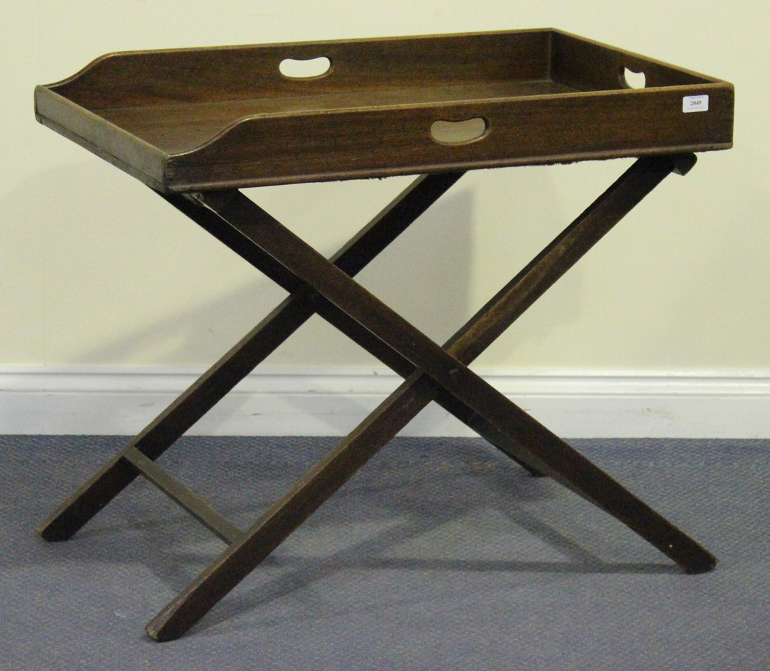 A 19th Century mahogany butler's tray and folding stand, the galleried tray with pierced handles,