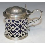 A Victorian silver mustard of cylindrical form with domed hinge cover and foliate capped scroll