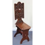 An early 20th Century Continental oak hall chair with a shaped rectangular back carved with a