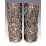 A pair of Chinese bamboo brush pots, early 20th Century, each carved in relief with figures in a