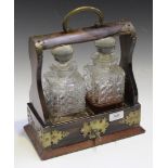 A late Victorian coromandel and brass mounted two bottle tantalus with hobnail cut glass