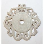 A Chinese pale celadon jade bi, 20th Century, the circular centre carved in low relief with a rice