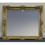 A late 19th Century Continental giltwood mirror, the frame with cartouche crestings and bellflower