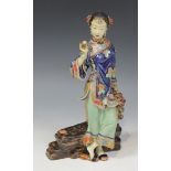 A Chinese pottery figure of a maiden, late 20th Century, modelled standing wearing a blue jacket,