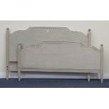 An early 20th Century French grey painted double bed frame with carved finials and arched ends,