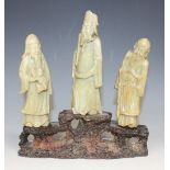 A set of three Chinese green soapstone carvings of immortals, late 19th/early 20th Century, modelled