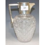 A late Victorian silver mounted cut glass claret jug, the cylindrical silver collar with hinge