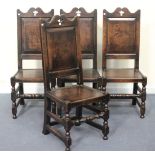 A set of four 20th Century Jacobean style oak dining chairs with shaped top rails above solid seats,