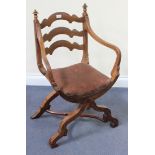 An Edwardian walnut Savonarola style armchair with a ladder back and two outswept arms, the padded