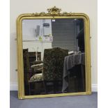 A late 19th/early 20th Century gilt composition overmantel mirror with a shell and scroll