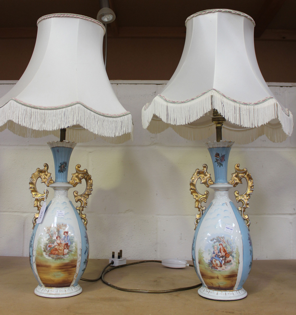 A pair of early 20th Century French porcelain vases, converted to table lamps, with gilt handles and