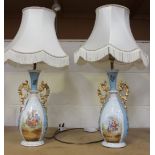 A pair of early 20th Century French porcelain vases, converted to table lamps, with gilt handles and