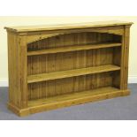 A modern pine open bookcase, fitted with two shelves flanked by channel moulded end supports, on a