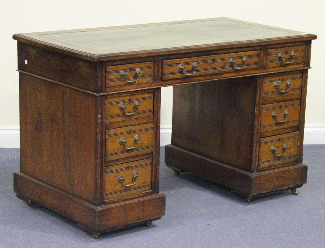 A late Victorian oak twin pedestal desk, the moulded top inset with green leather above an