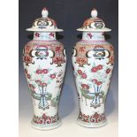 A pair of Chinese famille rose porcelain vases and covers, style of Yongzheng but late 19th Century,