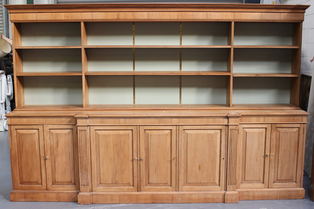 A 20th Century reproduction pine breakfront bookcase, fitted with open shelves above an