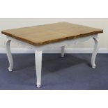 An early 20th Century French oak draw-leaf dining table, raised on white painted legs, overall