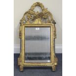A Louis XVI style giltwood and gesso framed wall mirror with an arrow, stiff leaf and flower