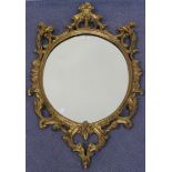 A 20th Century Italianate oval giltwood wall mirror with a carved scrollwork frame, approx 129cm x