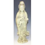 A Chinese green soapstone carving of Guanyin, 20th Century, finely modelled wearing an incised