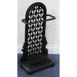 A Victorian style black painted cast iron stickstand, the pierced panel back above a drip pan,