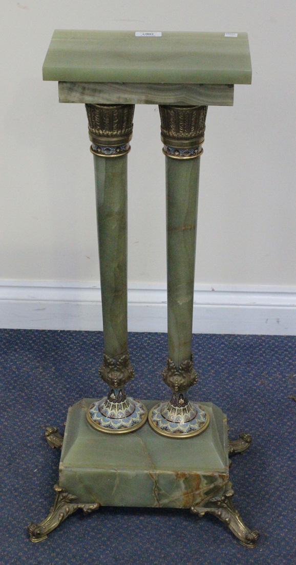 An early 20th Century green onyx and champlevé enamelled stand with overall gilt metal mounts, the