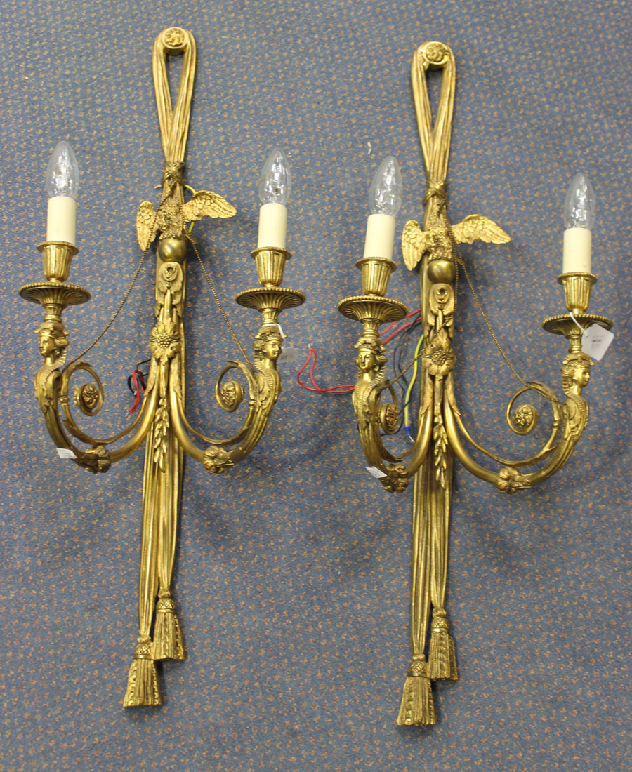 A pair of late 19th Century gilt cast bronze twin branch wall lights, each tassel effect back