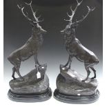 After Jules Moigniez - a pair of late 20th Century cast bronze figures of stags standing on rocky