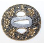 A Japanese brown patinated bronze oval tsuba, Meiji period, cast in relief with peony, picked out in