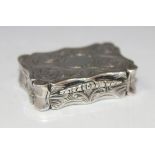A Victorian silver rectangular vinaigrette engraved with foliate scrolls within a shaped rim, the