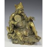 A Chinese gilt bronze figure, 20th Century, modelled seated holding a fan and an insect, on a