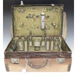 An early 20th Century leather vanity case, the interior partially fitted with silver mounted and cut