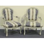 A pair of early 20th Century Louis XV style white painted showframe fauteuil armchairs, raised on