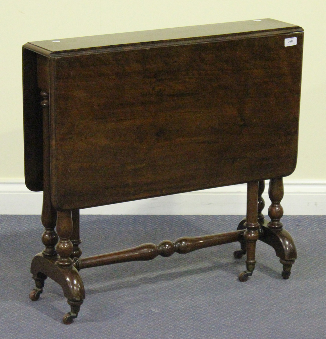 A Victorian walnut Sutherland table, on turned supports and outswept feet, terminating in brass caps