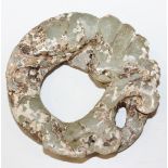A Chinese partially calcified jade bi carving, modelled as a coiled dragon, diameter approx 6cm.