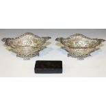 A matched pair of Victorian silver sweetmeat baskets, each of oval form, with pierced and embossed