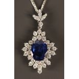 An 18ct white gold, sapphire and diamond pendant, the central oval cut sapphire in a shaped surround