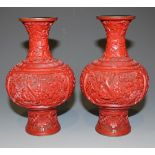 A pair of Chinese cinnabar lacquer vases, late 19th Century, each bulbous body carved in relief with