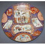 A large Japanese Imari porcelain circular dish, Meiji period, painted with figural panels within