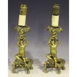 A pair of 19th Century gilt cast metal table lamps, each in the form of a cherub holding a grape-