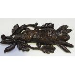 A 19th Century carved oak wall mount in the form of a rabbit hung from a stylized rope, flanked by