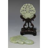 A Chinese pale celadon jade circular plaque, Qing dynasty, pierced and incised with a flower