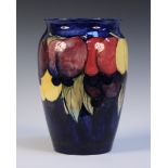 A Moorcroft pottery vase, circa 1920s, decorated with Wisteria design against a blue ground,