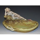 An Art Nouveau Royal Dux porcelain centrepiece bowl, modelled as a recumbent maiden musician resting