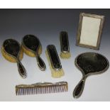 A George V silver and tortoiseshell five piece dressing table set with piqué inlaid decoration,
