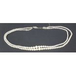 A two row necklace of graduated cultured pearls on an oval gold clasp, detailed '9ct', shortest