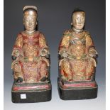 A pair of Chinese carved wood and gesso figures, probably late Qing dynasty, modelled as a seated