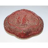 A Chinese cinnabar lacquer box and cover, 18th Century, of ruyi head form, the top carved in